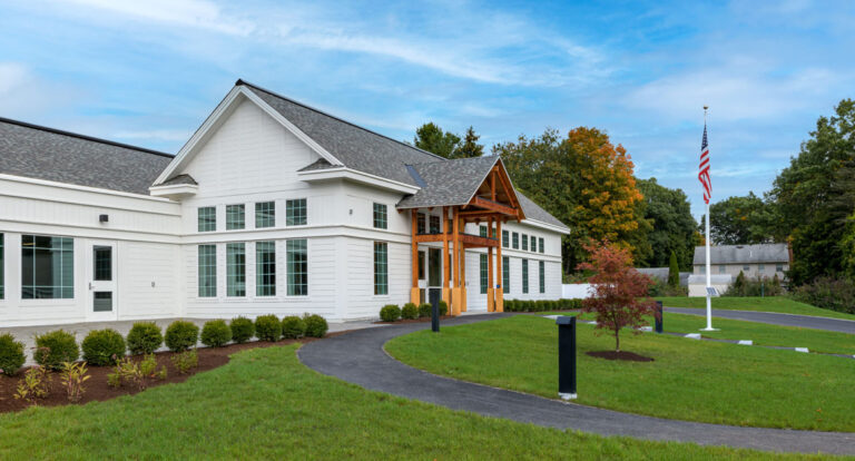 Patio and side view of North Hampton Public Library with walkways leading up to entrance