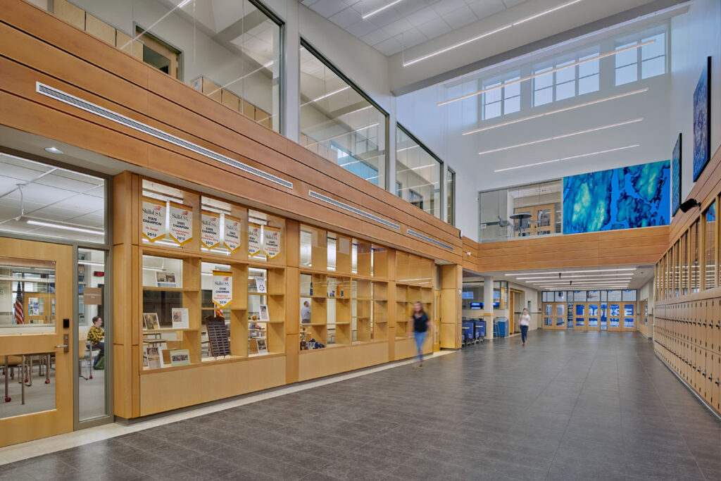 A photo of the Long corridor towards gymnasium with center classroom and upper hallway at Morse High School
