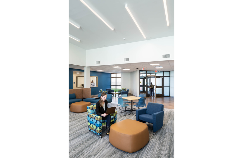 Vertical view towards interior entrance of UNH Health Sciences Sim Center, with seating in foreground.